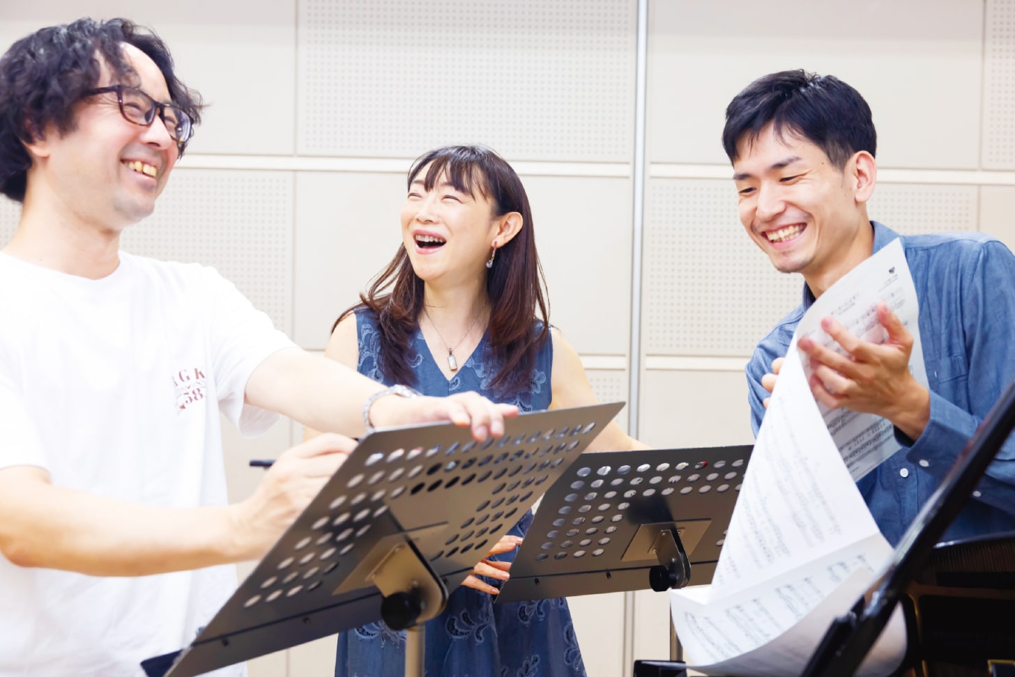 ピアニストと声楽家が音を合わせながら、笑顔を交わす練習風景。